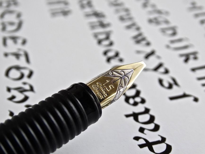A fountain pen writing on paper by hand, the human touch behind human led content